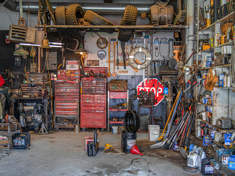 Vollgestellte Garage mit Werkzeug und Regalen (vorher, Symbolbild)
