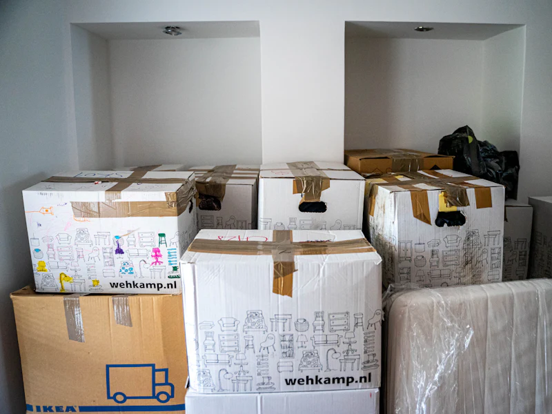 Gepackte Kartons in einem leeren Zimmer (vorher, Symbolbild)